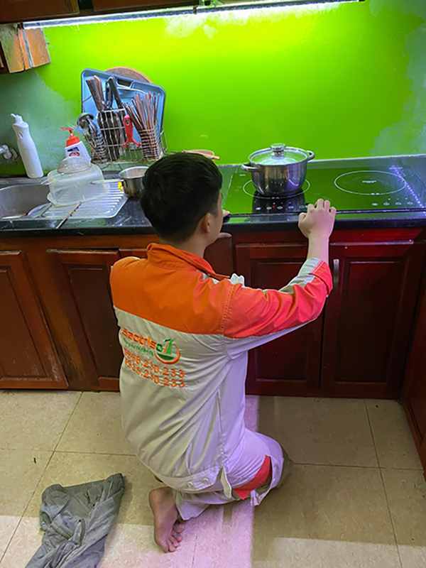 Thợ sửa bếp từ đang kiểm tra bếp
