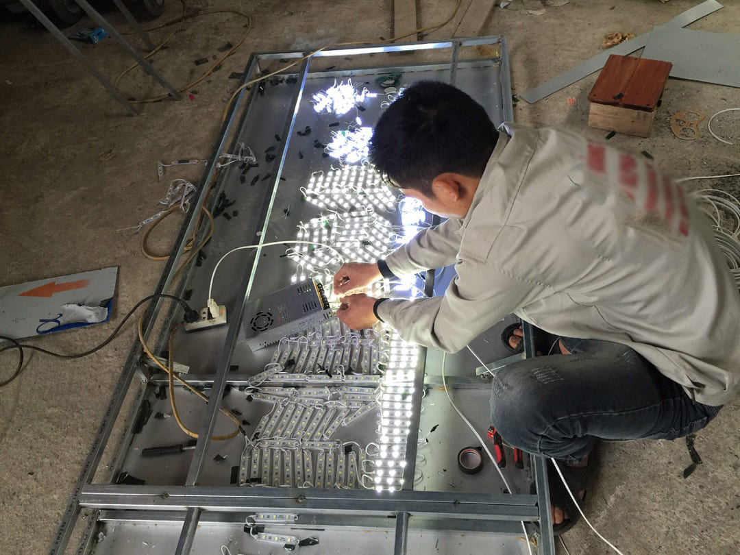thợ chỉnh đèn led trước khi lắp đèn pha bảng hiệu lên